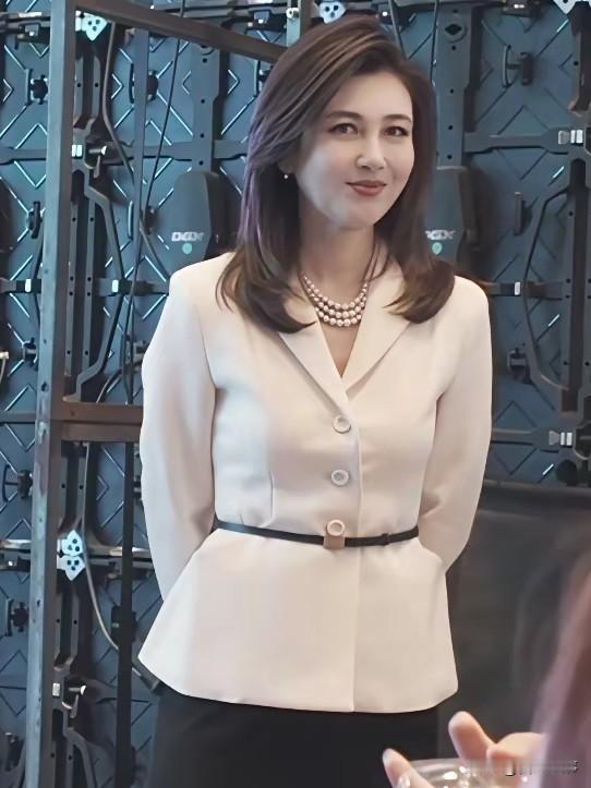 央视老牌女主播录制休息间隙的照片，原生容貌惊艳动人。镜头下，48岁的李红身着米白