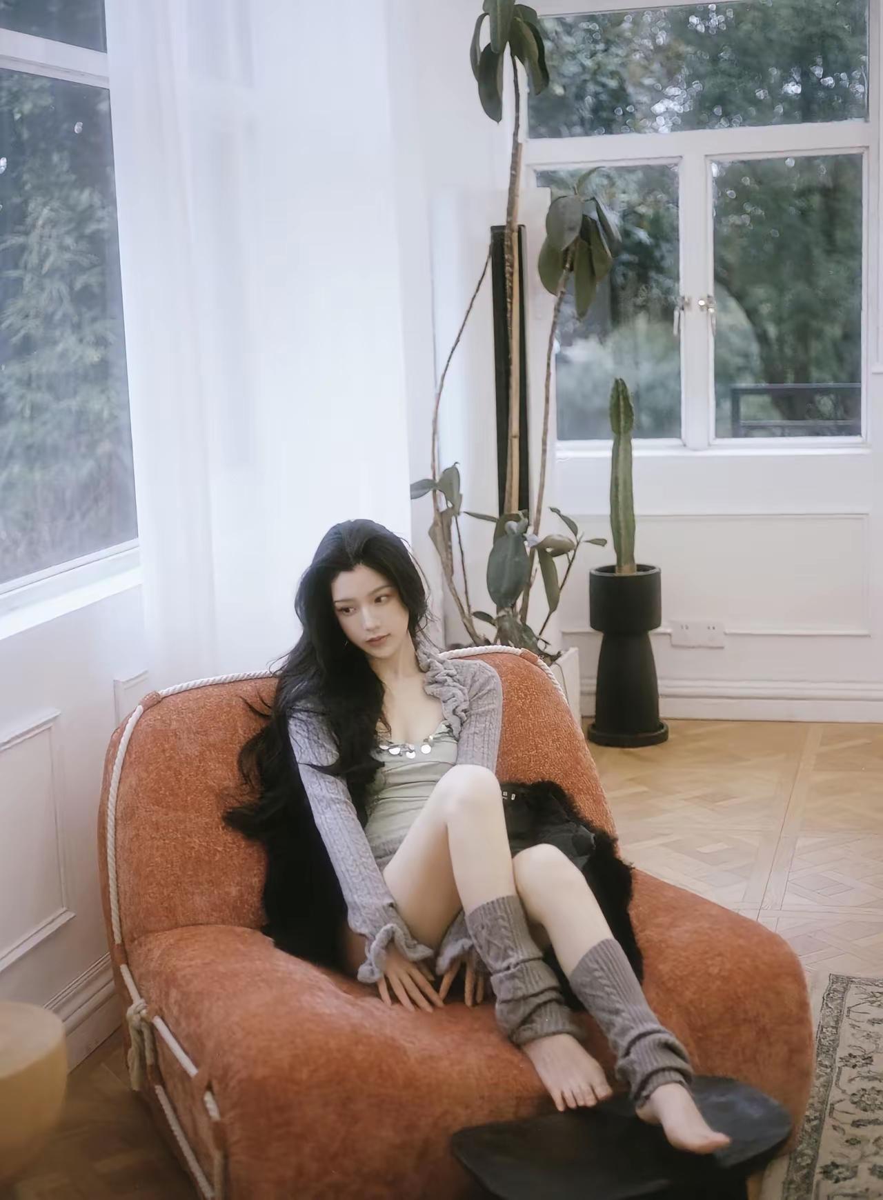 慵懒午后，黑发美人倚靠在复古沙发上，享受宁静时光。中午你有睡午觉的习惯吗买什么