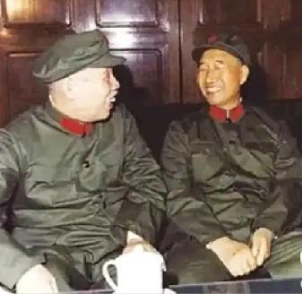 这是两位开国元帅的合影。他俩紧挨着坐在一条板凳上，促膝长谈，