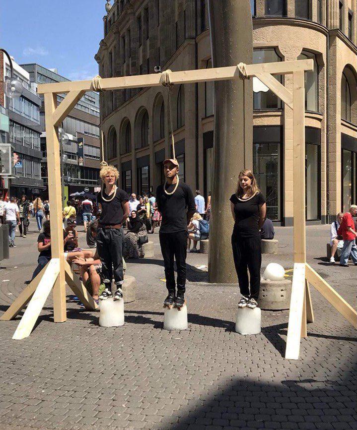 德国气候活动家站在融化的冰块上，脖子上套着绳索，警告时间不多了。这个装置艺术简单