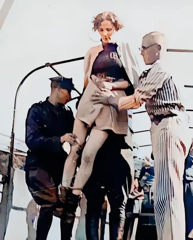 1946年，波兰旦泽，一名年轻的女纳粹即将被送上绞刑架，此时她正在被两名波兰士兵