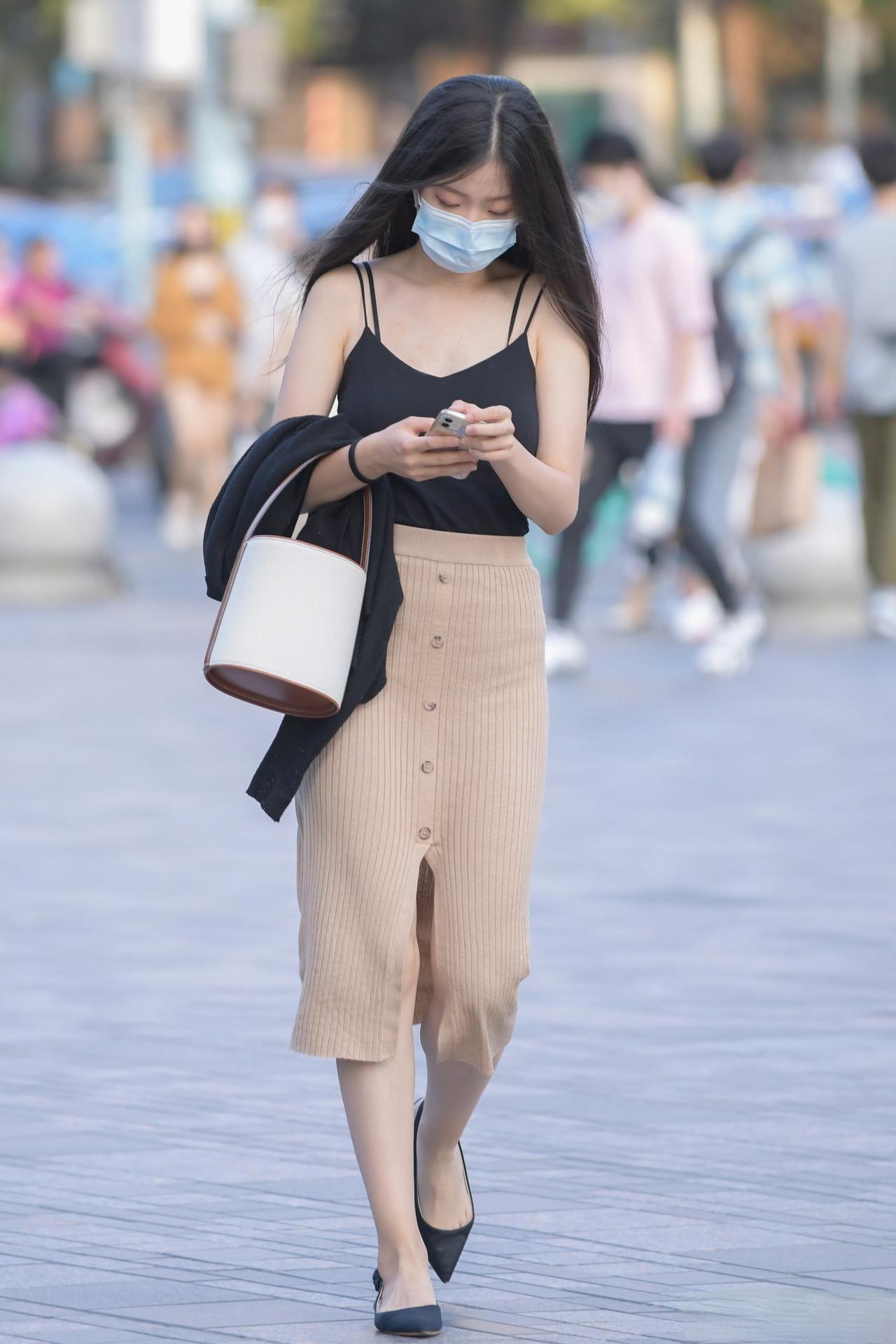 黑色吊带勾勒利落肩颈线条，搭配针织半裙，柔中带刚尽显随性气质。基础款组合却藏着小