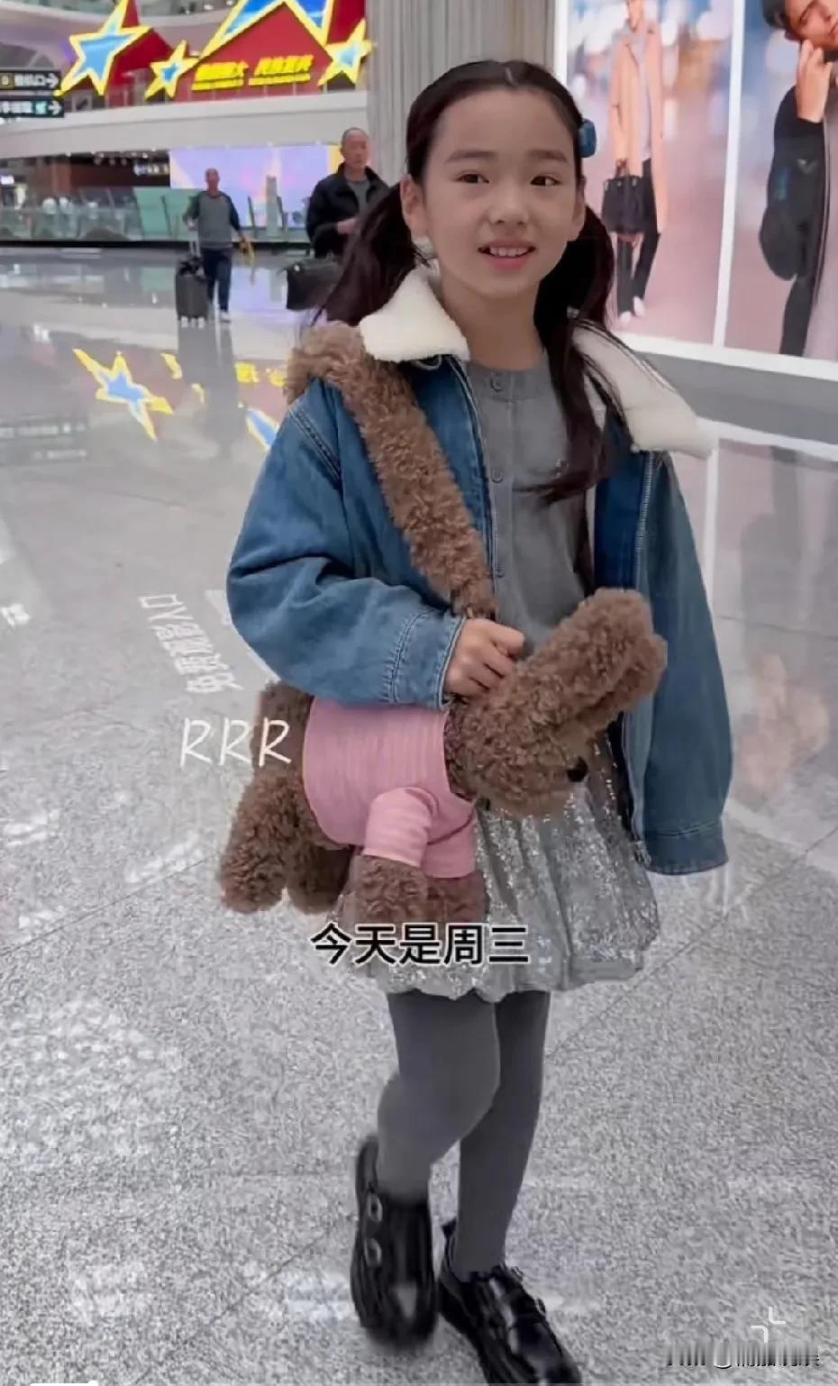 小酒窝现身机场,扎着两个俏皮的马尾,背着自己粉色的小兔包包,活泼可爱,性子大大方