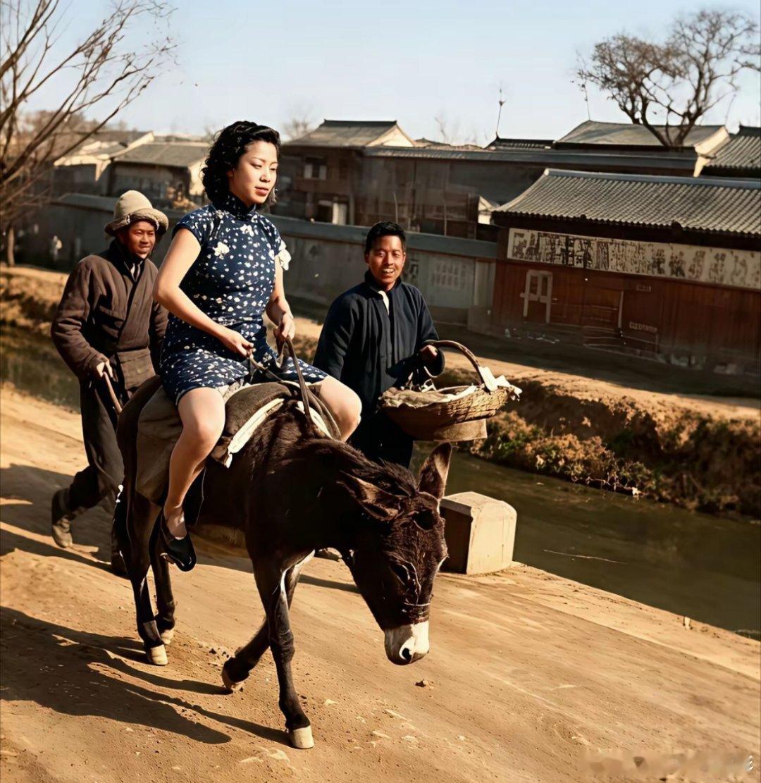 照片是假的！赶驴的戴皮帽，穿寸棉袄，远景的树是枯枝无叶，骑驴女人着夏装。照片是p
