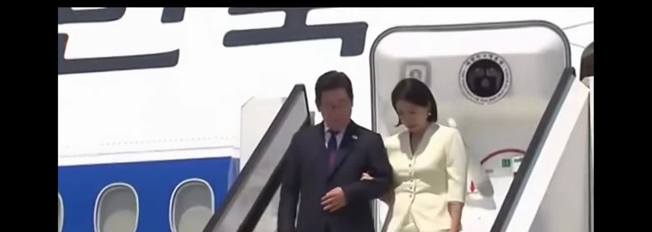 这是韩国总统李在明携夫人金惠景抵达日本下飞机的场景，但是看到李在明与夫人金惠景下
