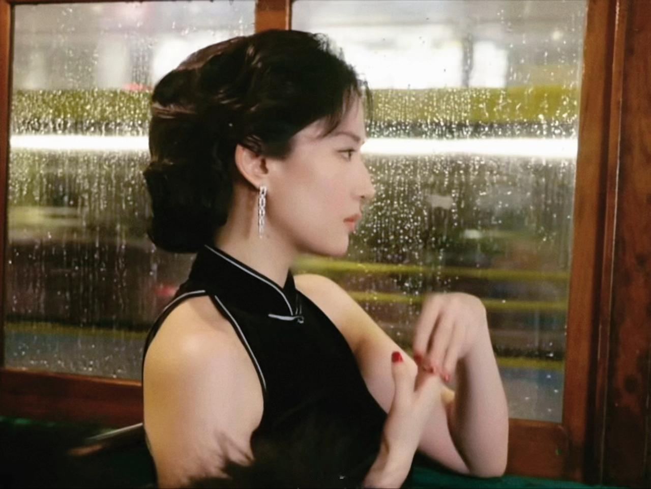 旧电车、雨夜玻璃窗，身着黑旗袍的她静静倚靠窗边。眉眼清冷又带着淡淡的怅然，氛