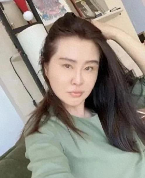 王祖贤穿着居士服在机场，推着粉色行李箱，额头凹凸不平显老态58岁的她穿居士服现