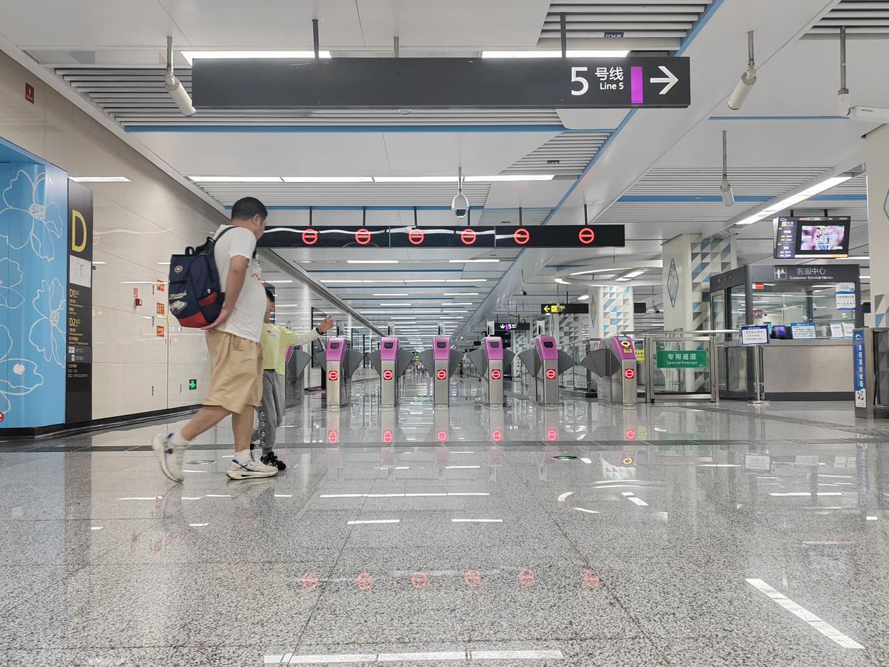 成都地铁5号线乘车人络绎不绝大手牵着小手顺着地铁出入口向远方走去脚步随