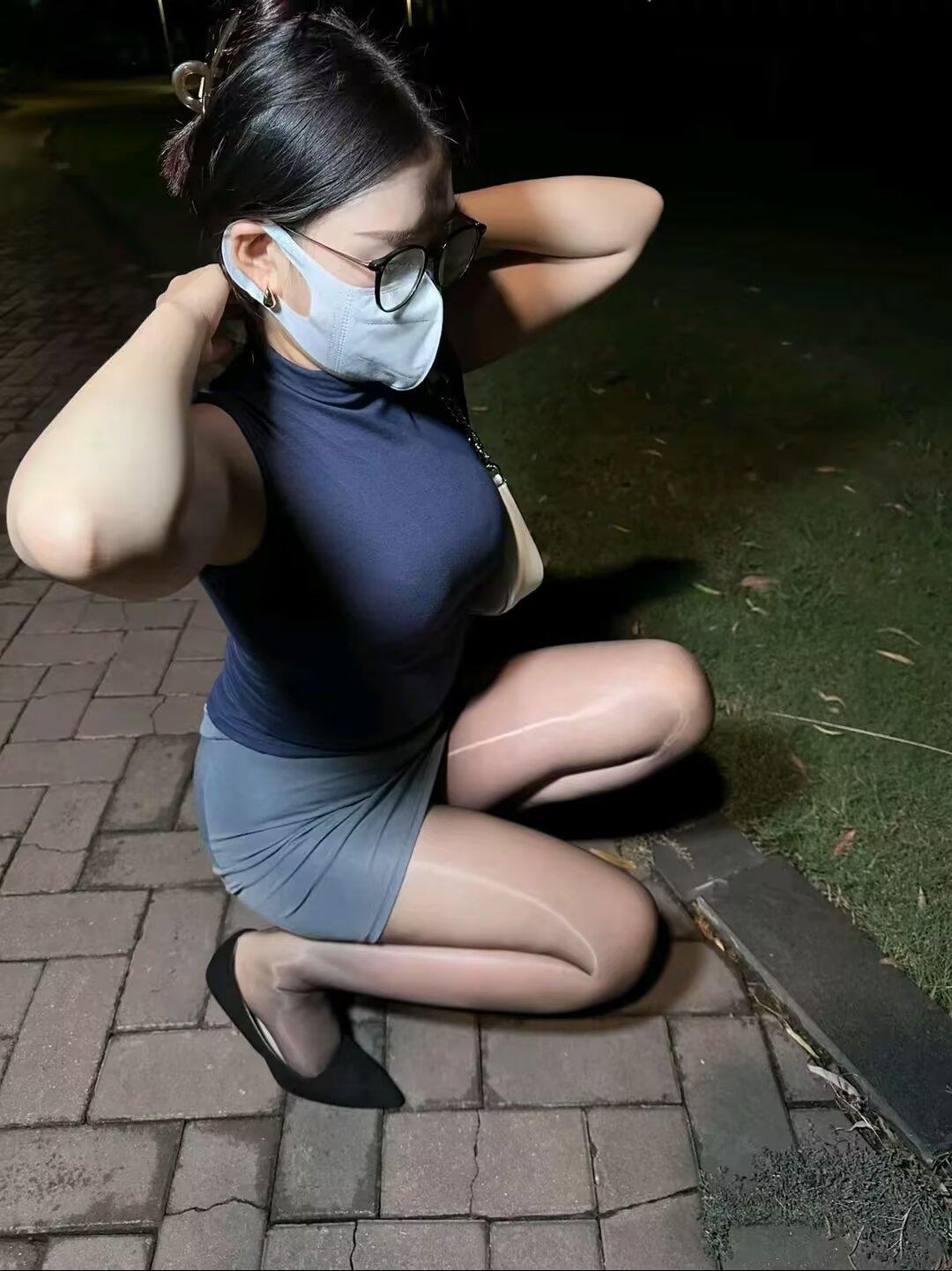 晚风裹着夜色漫过脚踝，油亮丝袜在路灯下泛着细碎的光，细高跟敲在砖路上，是独属于夜