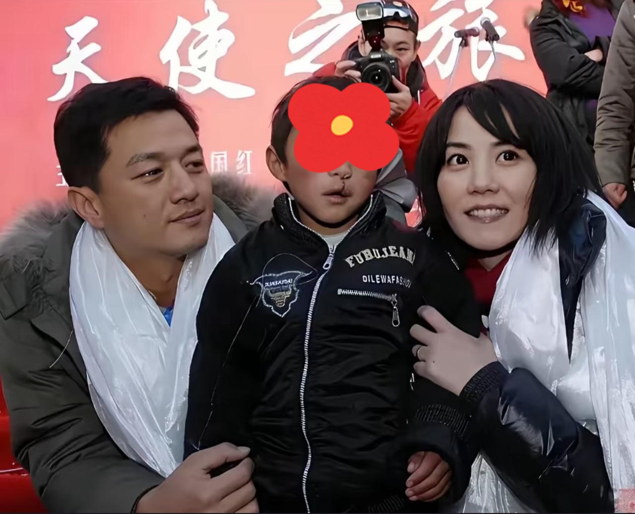 当年，李亚鹏和王菲与一位唇腭裂小男孩一起合影，这个小男孩当时还没有做手术，相信后