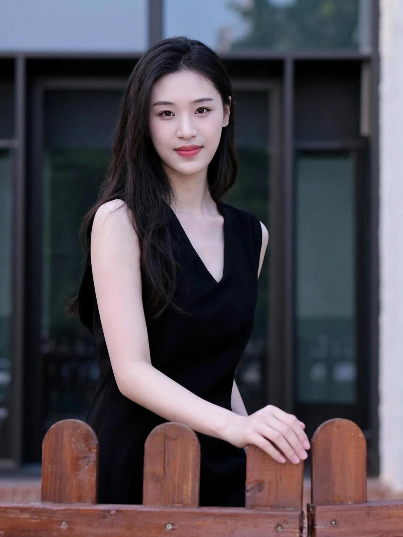这黑裙的质感，简直是“低调中的奢华”代表。阳光洒在身上，仿佛自带柔光滤镜，连空气