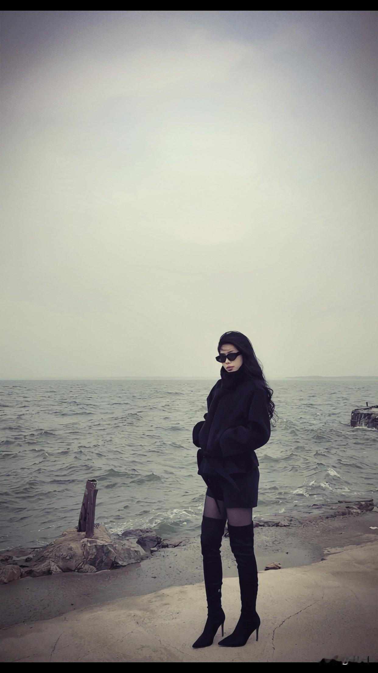 分享唯美的美照海边漫步，黑色外套与长靴的时尚搭配，尽显酷炫风格。