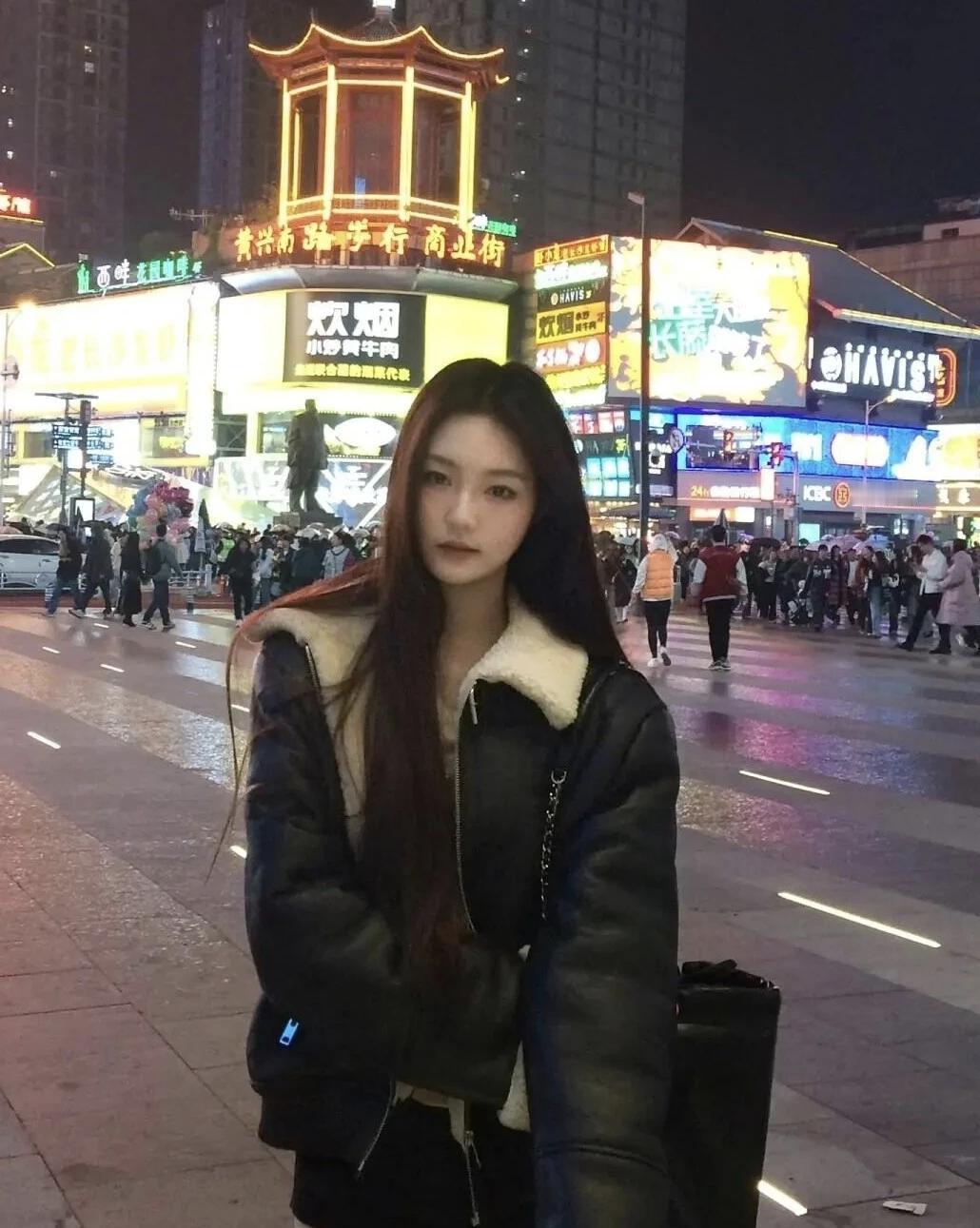 🌃裹着带毛领的皮衣，站在黄兴南路的霓虹里，让烟火气和晚风一起漫过肩头。热闹的