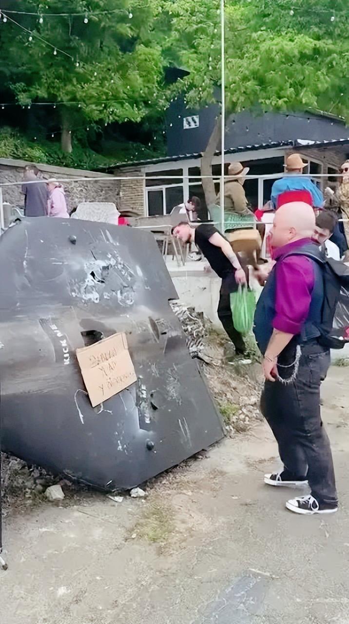 乌克兰一家酒吧外面搁置了一架缴获的俄军天竺葵无人机，老板准备了一把木榔头，供客人
