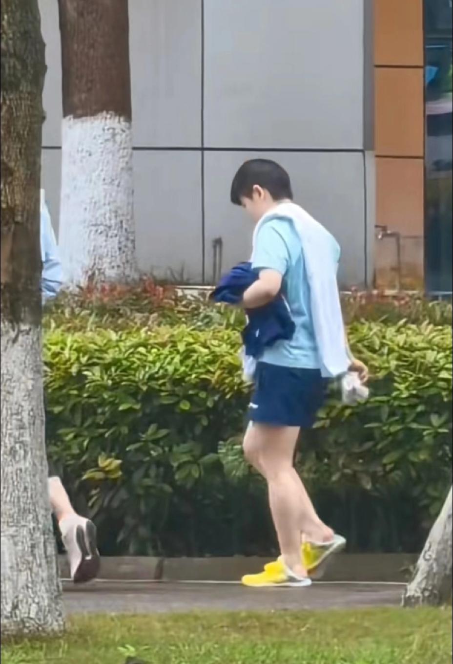 莎莎一手拿着袜子，一手抱着衣服，光着脚丫踩着鞋子，这都被球迷们拍的清清楚楚