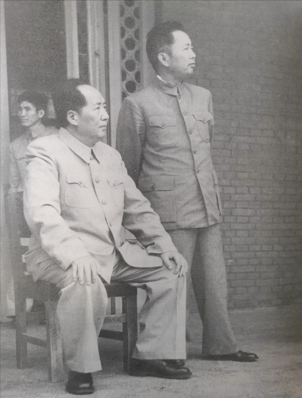 这是一张1956年10月的老照片。毛主席端坐，显得气定神闲。旁边站着一位器宇轩昂