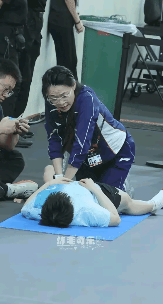 莎莎的队医姐姐，满脸宠溺的看着莎莎。队医给莎莎按摩时，莎莎躺着。队医姐姐跪着。