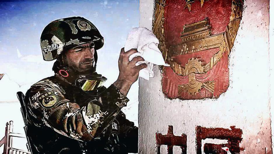 塔吉克族边防战士正在擦拭国界碑上的中国国徽