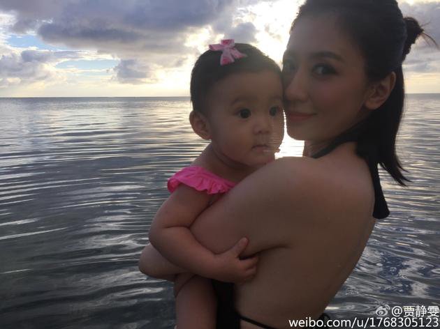 贾静雯抱女儿海边玩耍 穿比基尼秀美背