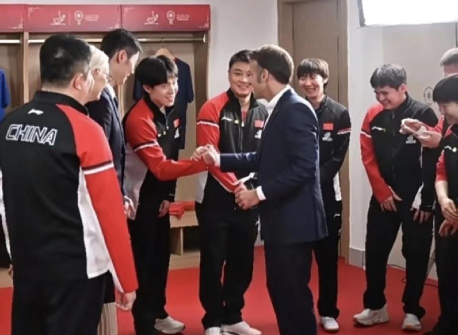 你能想象吗？马克龙和头哥握手时，周围人居然集体笑场了！连身边的莎莎都捂着嘴偷笑，