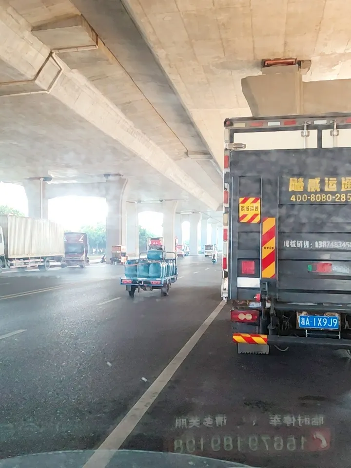 高架桥下堵车，车流缓慢。桥底下好多车，貌似都是在这里等单的