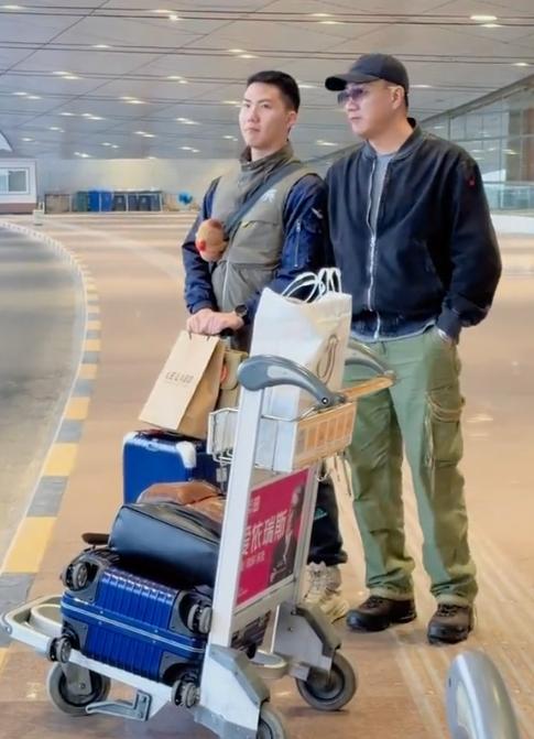 网友在机场拍到了胡军父子，17岁的康康已经长得和父亲差不多高了。理了个寸头，打扮