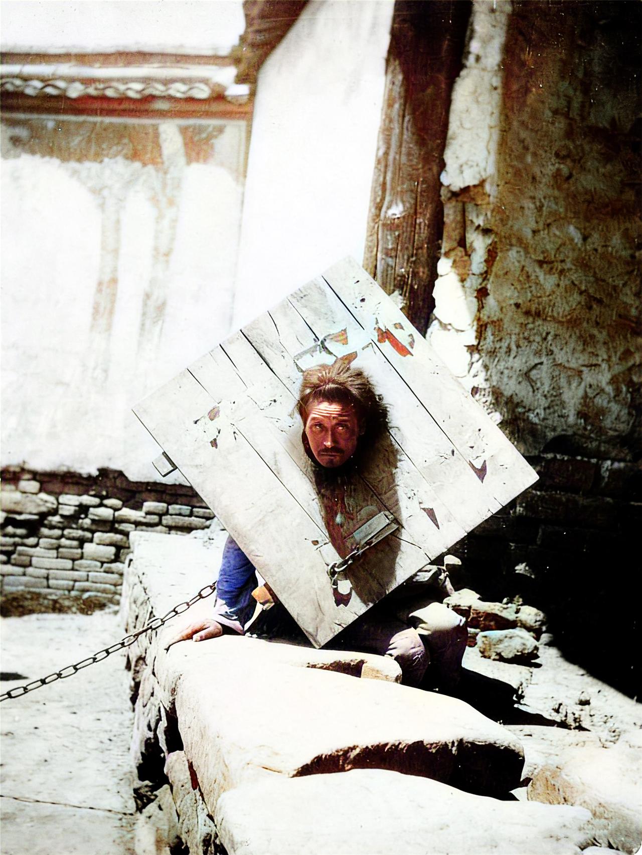 清末时期，一名在街边示众的囚徒，匍匐着身体，正在用犀利的目光注视着拍照的洋人。