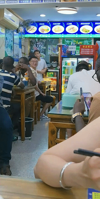 浙江杭州一家小餐馆里，有两桌来自非洲国家的黑人正在这里吃饭？这些黑人在吃饭的时