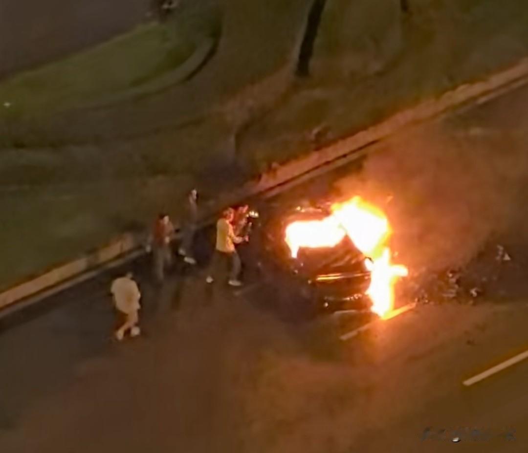 成都小米su7撞到绿化带发生起火，驾驶员还被困车里，众人拿着工具砸窗救人。发生