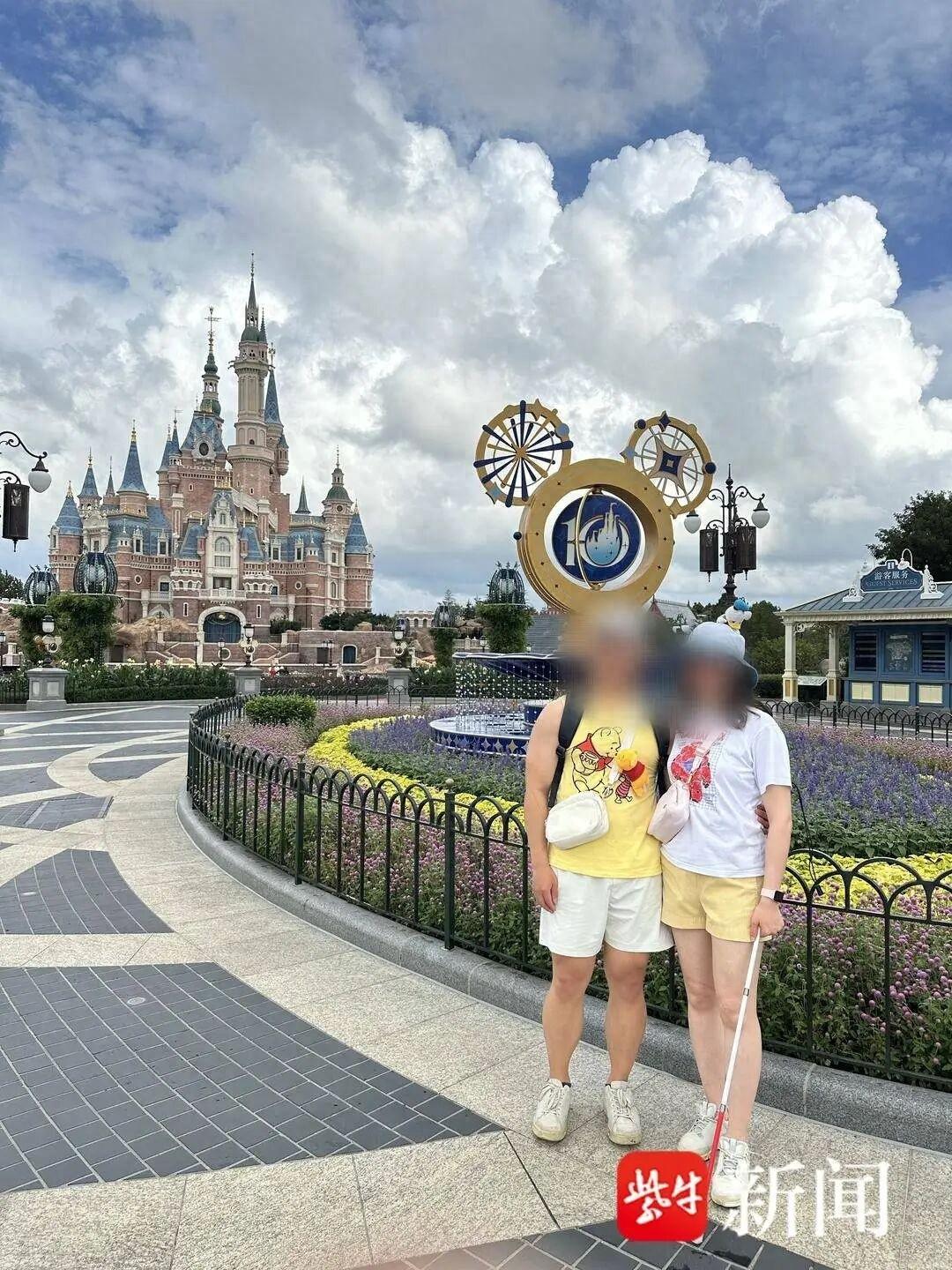 上海迪士尼乐园，一名视障女性游客和男友一起入园游玩，在花园位置，请求工作人员帮忙