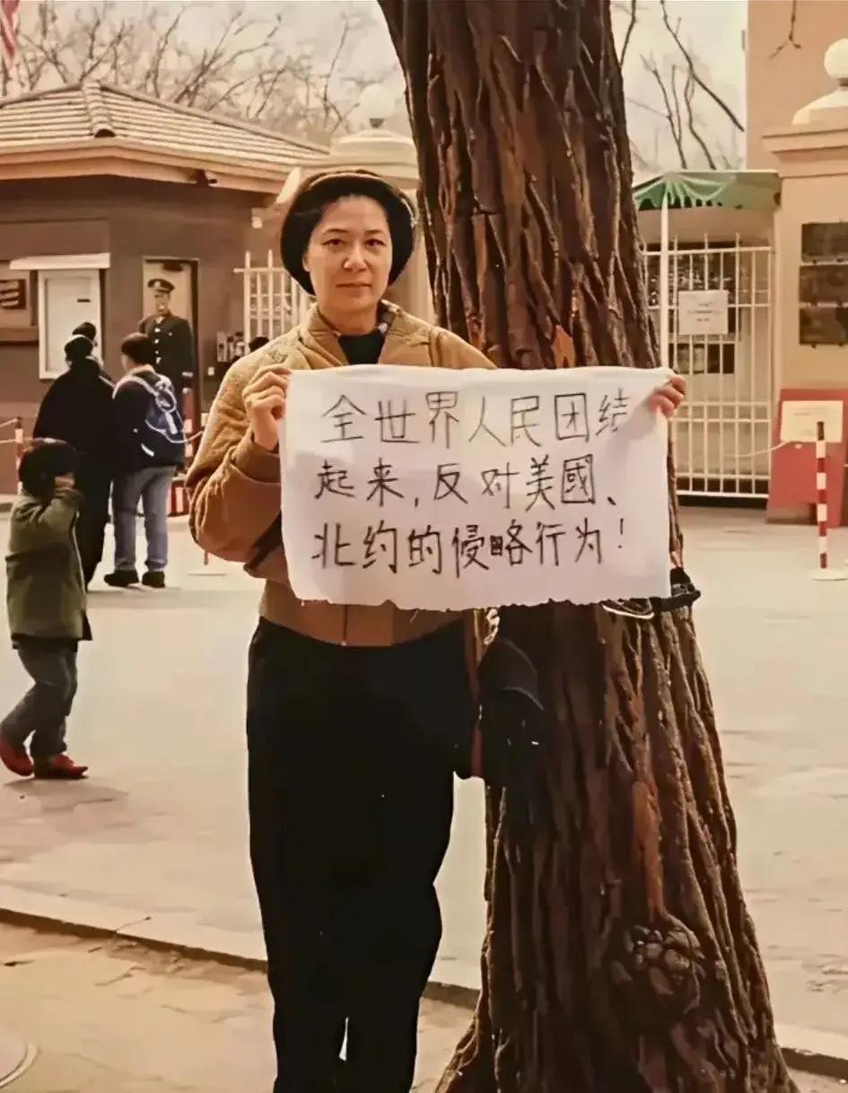 这是拍摄于1999年的一张老照片，地点美国大使馆门前，一名大姐举牌抗议，表达着自