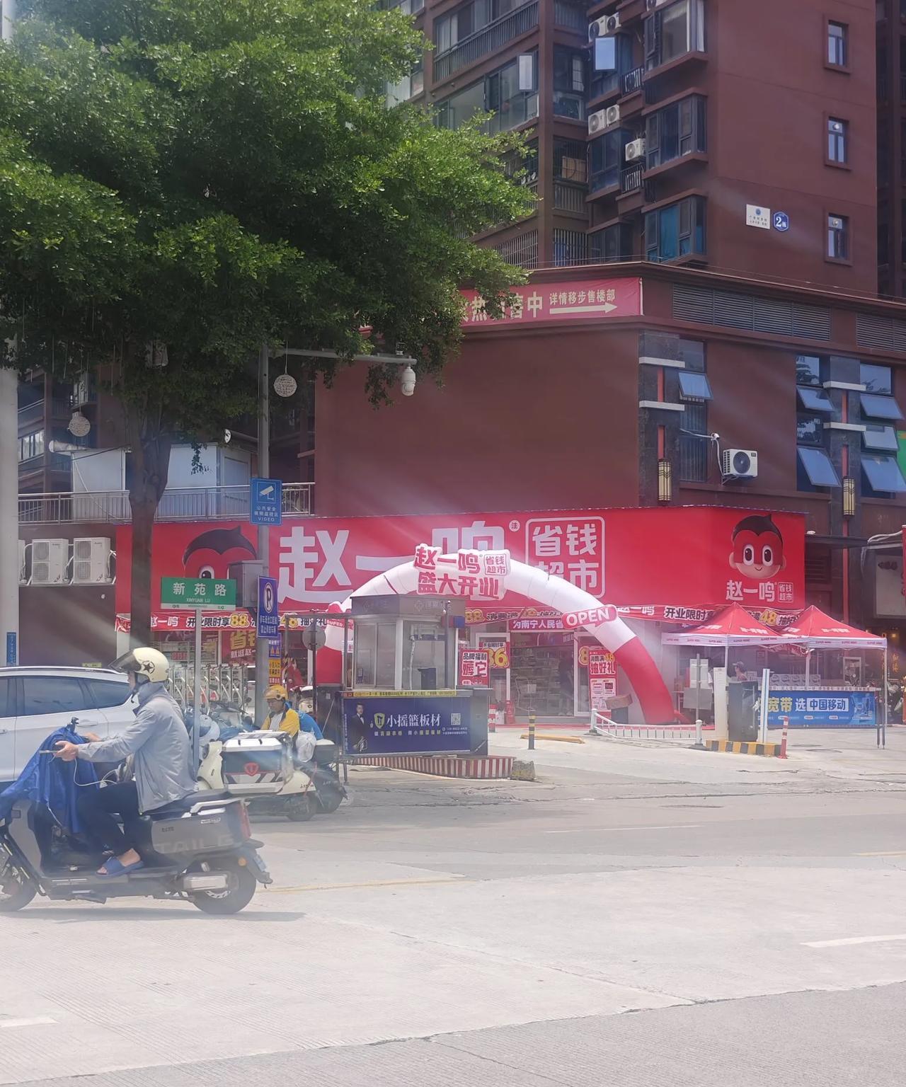 在南宁科德路上新开了一家赵一鸣零食店。路边有许多宣传标语，像“新店开张”“省钱超