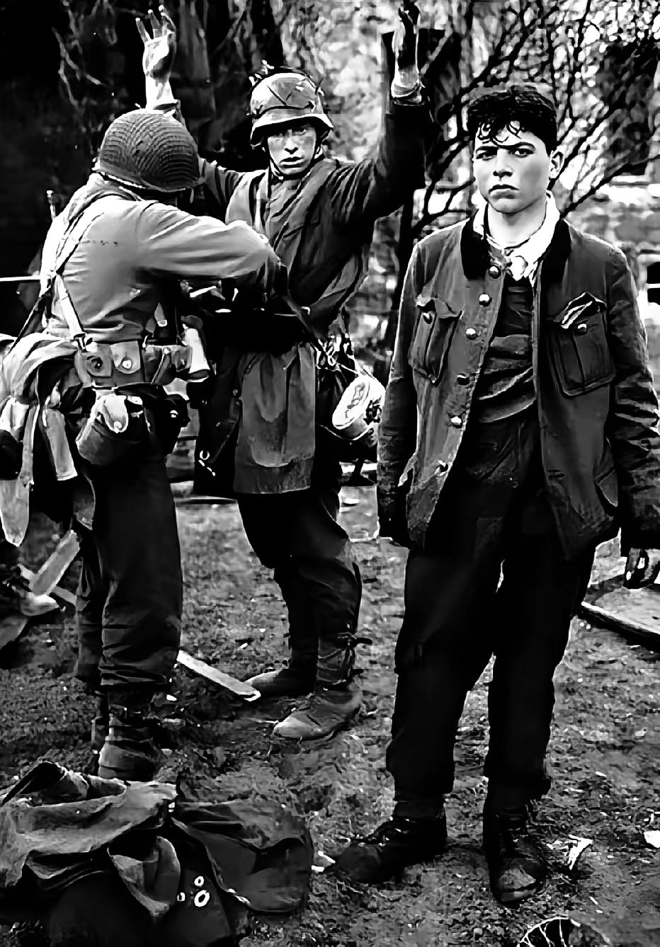 1945年，美军攻占德国科布伦茨市，两名德军狙击手在弹尽粮绝下被俘，一个高举双