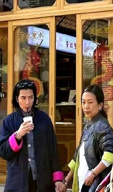 相差14岁，53岁的女人素颜顶着皱纹逛街，39岁的男星不仅死死攥着她的手，还乖乖