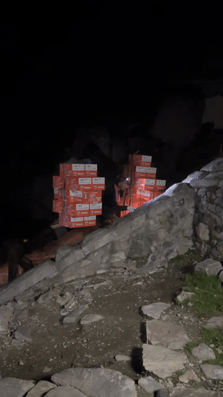 凌晨一点的山东泰山风景区。一位年迈的挑山工大爷肩上扛着很多方便面正艰难的向山顶