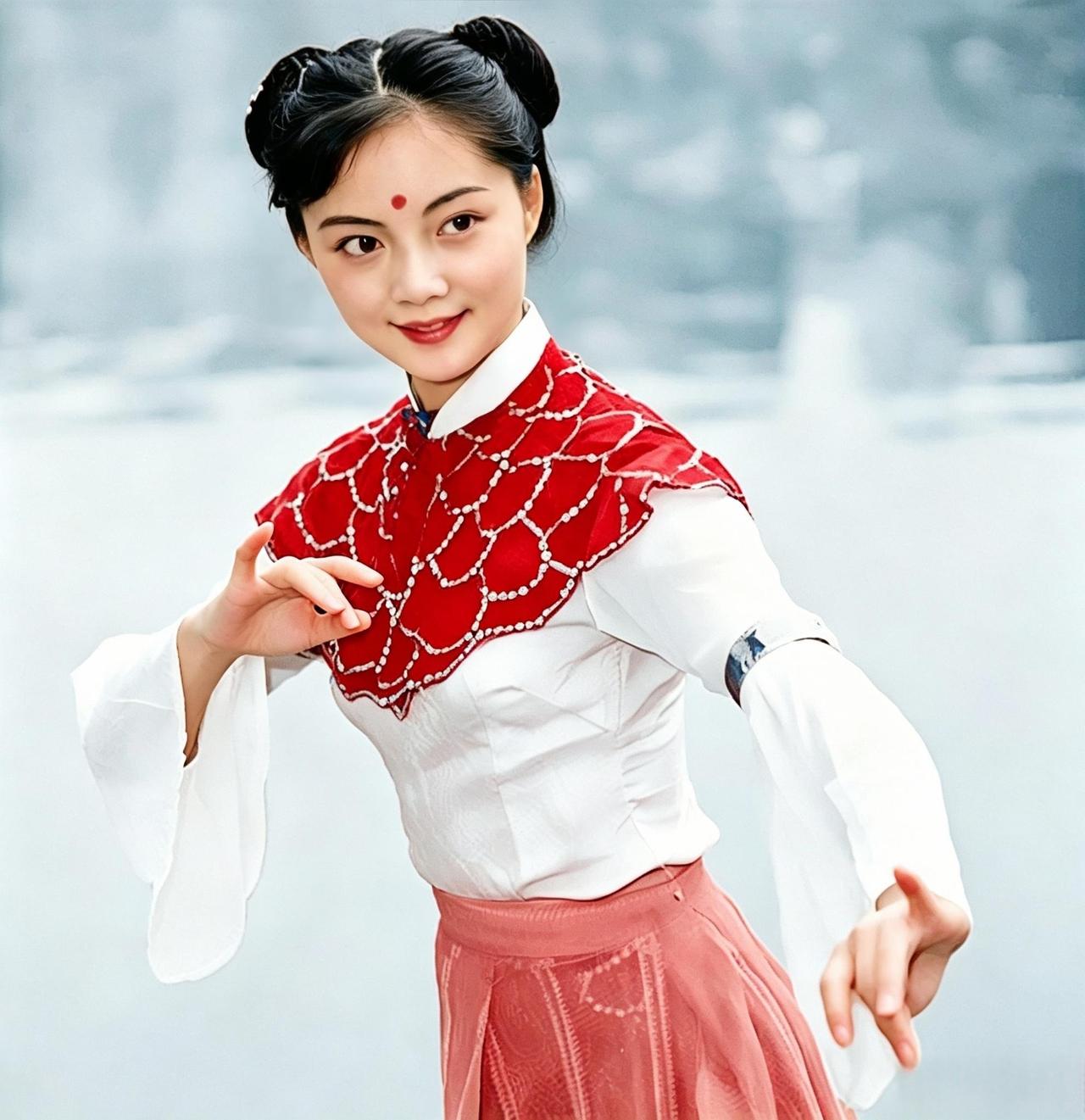 这位梳着双髻、额点朱砂的姑娘，回眸一笑，把"面若银盘、肤如凝脂"八个字演活。她正