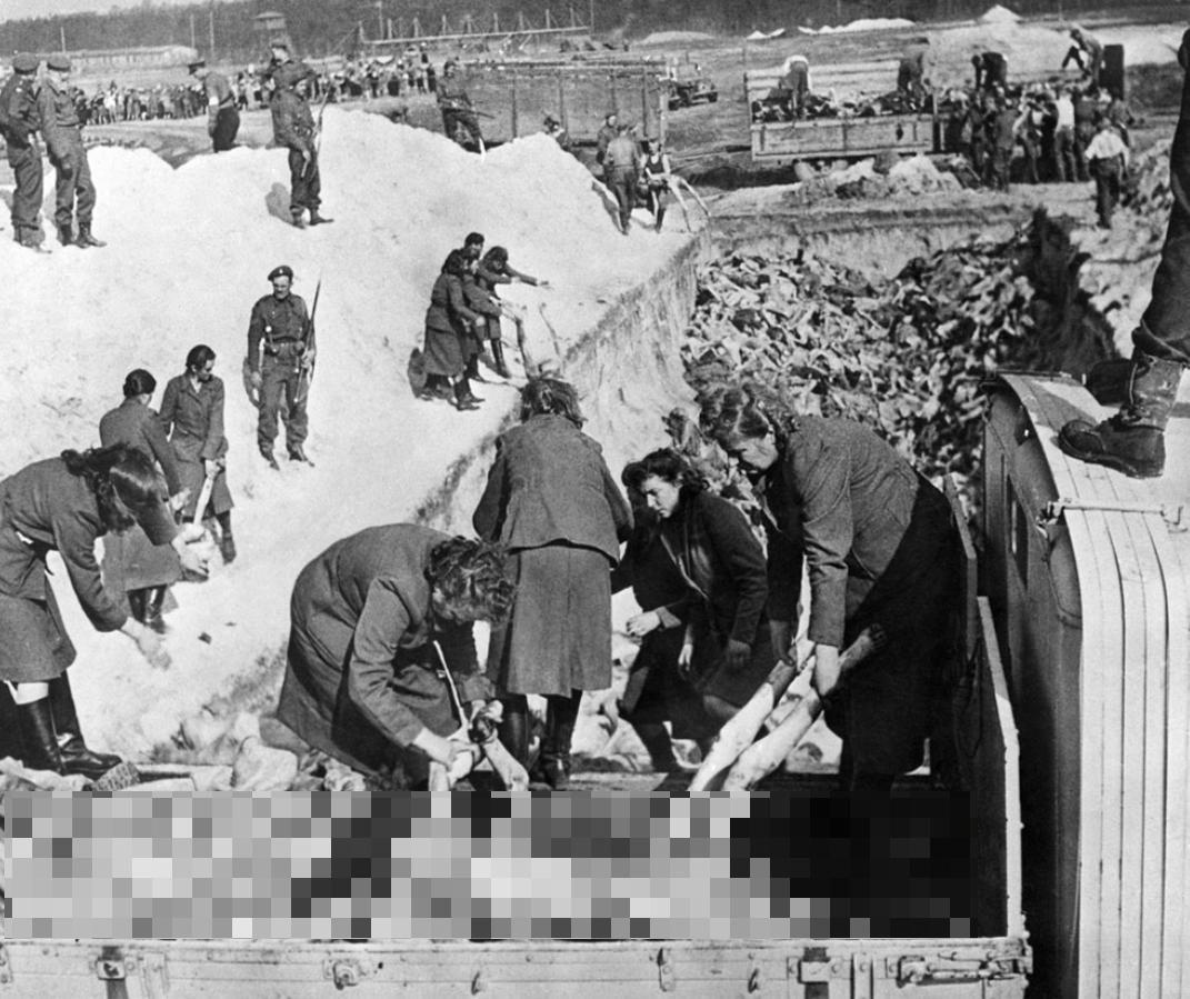 1945年4月28日，德国贝尔根-贝尔森集中营，女党卫军卫兵被迫掩埋受害者。一