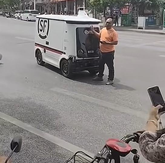 大哥开车被无人驾驶车刚蹭拦着无人驾驶车不让它走这种情况要找谁负责