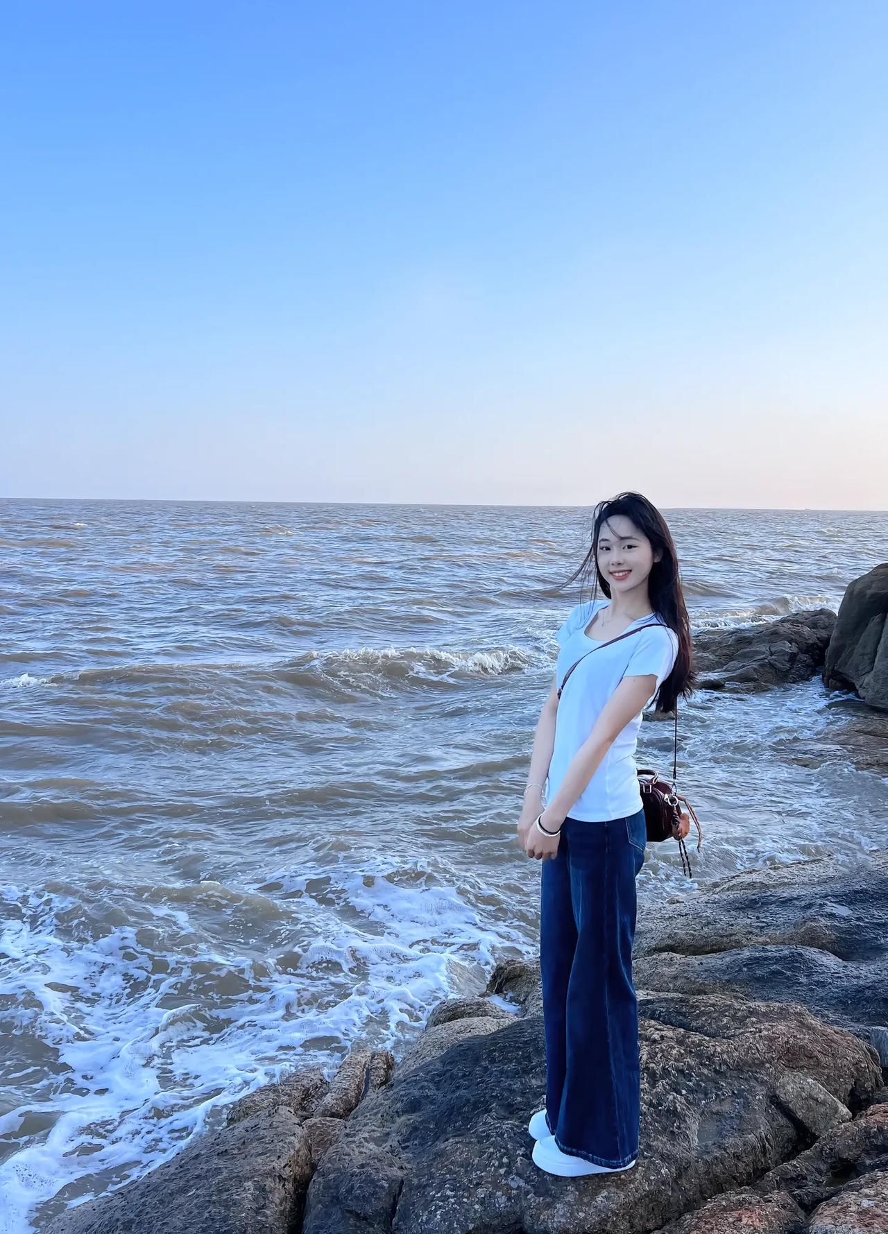 海风吹拂，美人倚石。