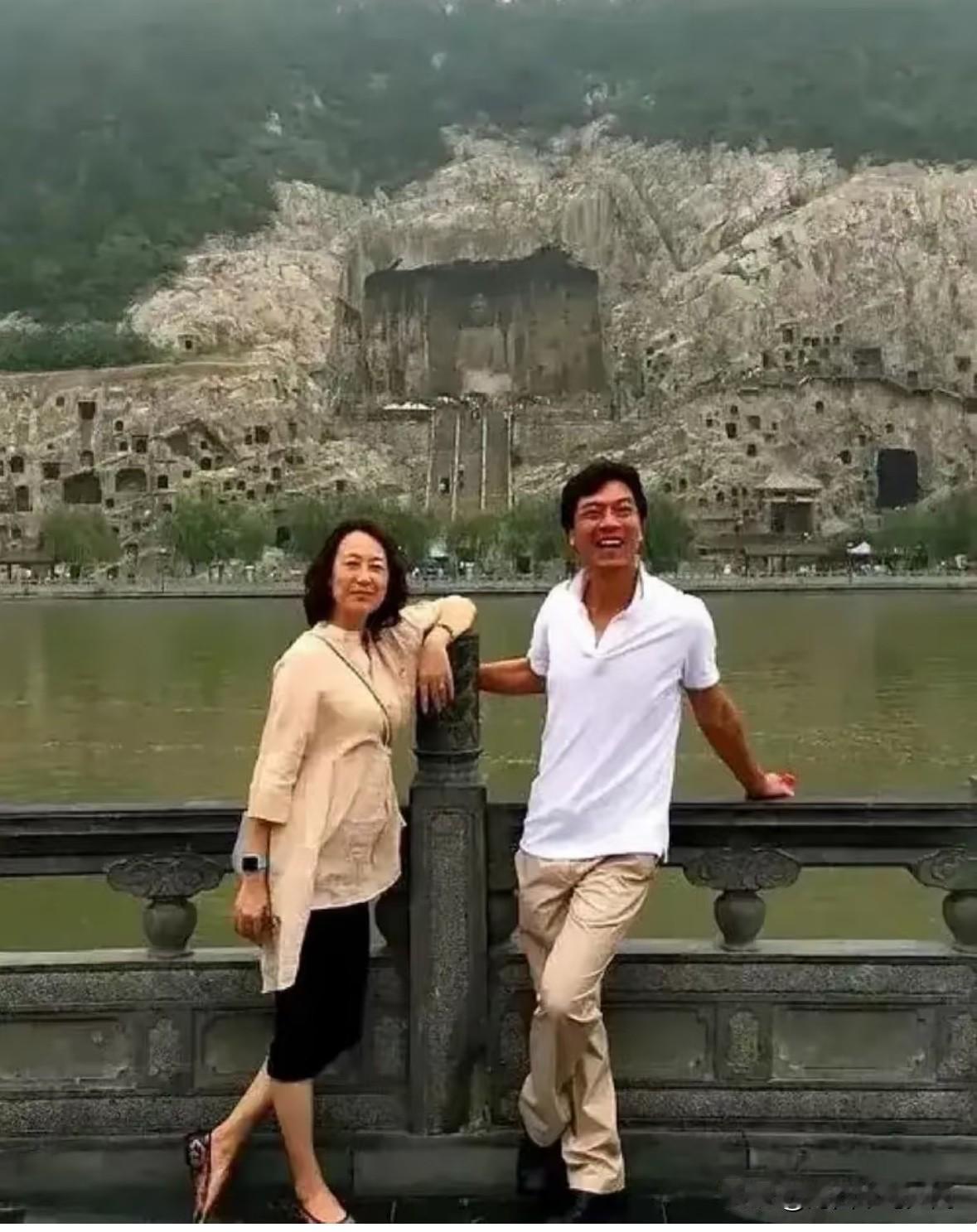 乒乓球名将江嘉良与妻子吴玉芳，在龙门石窟的石刻景观前的一张合影。吴玉芳穿着宽松休