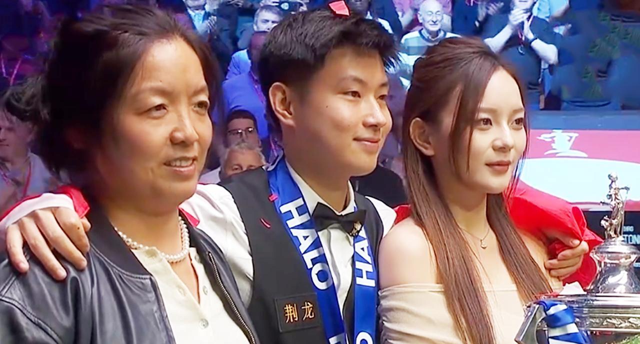 这是赵心童在击败威廉姆斯后，获得2025斯诺克世界锦标赛后，两个女人站在他身旁，