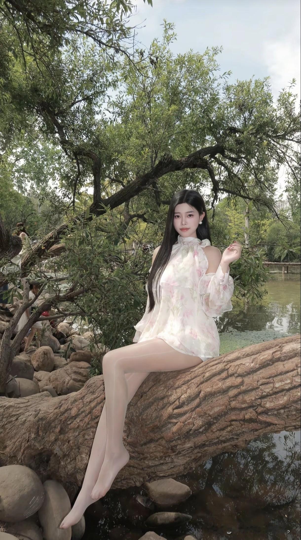 她坐在湖边的木栈道上，风景真美。湖边温柔少女湖边的小女孩湖畔木栈道