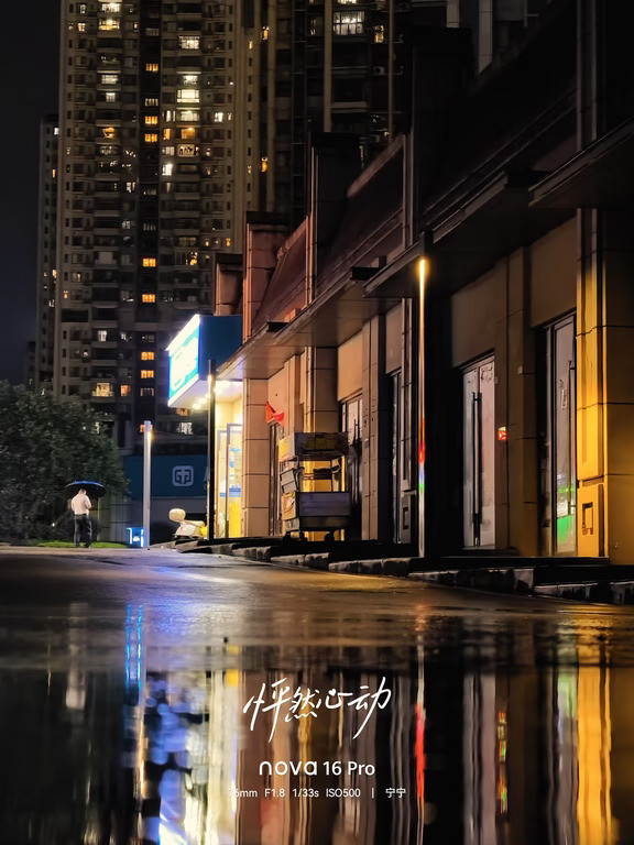 细雨绵绵的夜晚下楼闲逛。华为Nova16拍下小区雨夜灯火。雨幕晕开暖黄灯光，积水映着万家灯火。不用复