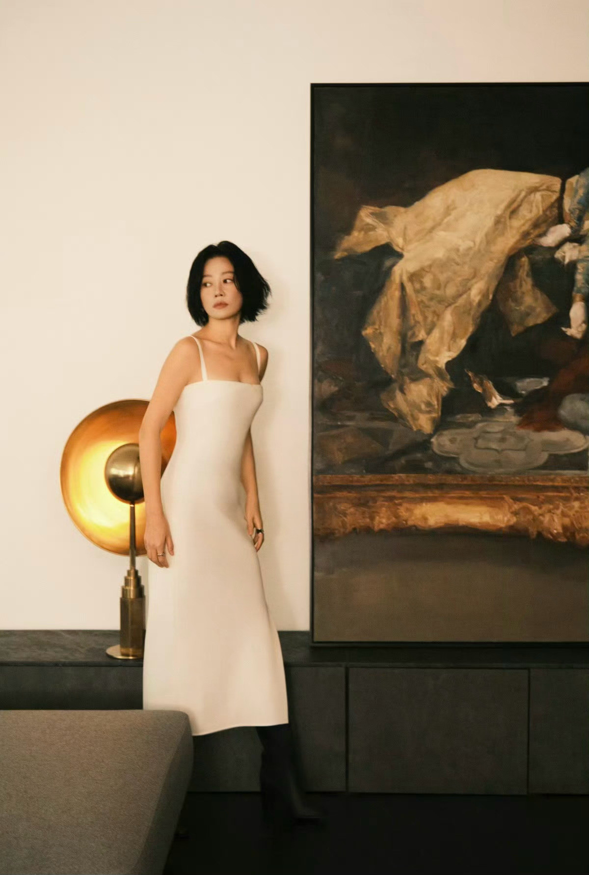 演员谭卓身穿Hermès2025秋冬女装系列白色真丝吊带连衣裙，脚穿黑色小牛皮