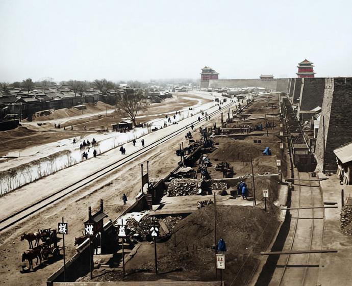 清末，北京内城城墙根下冬季运煤、卖煤。照片视角从城墙上俯拍，远处可见德胜门和安定