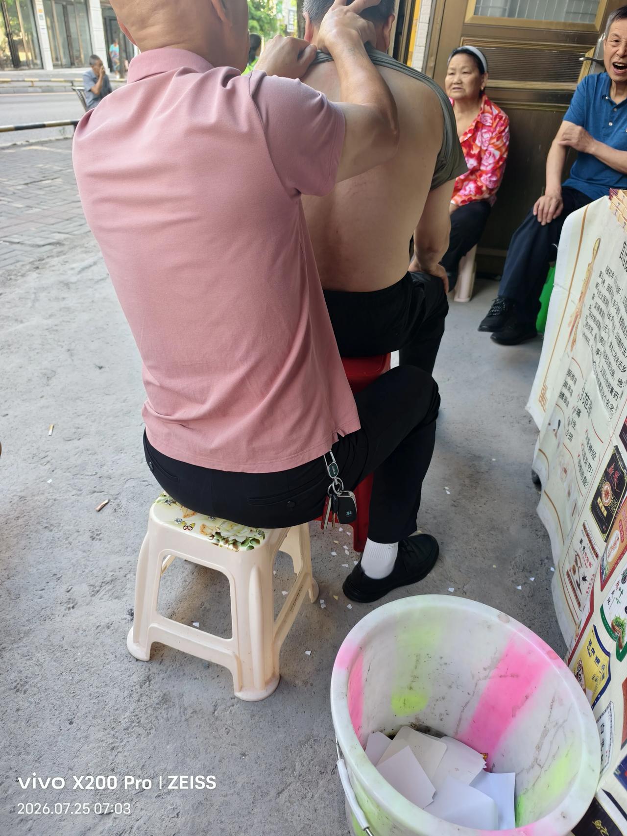 这是今天早上在杉木公园拍的几张照片，这是一个年轻的女子在公园旁边摆的一个剃头按摩
