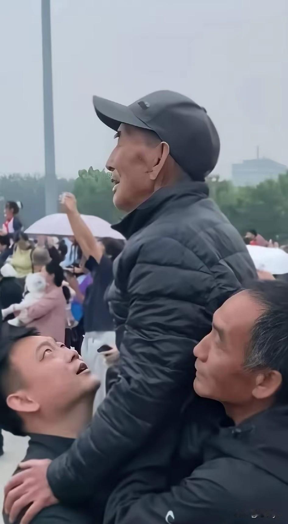 叔侄合力托举老人看升旗。9月29日，天安门广场，来自山东济宁86岁老人姬长千，在