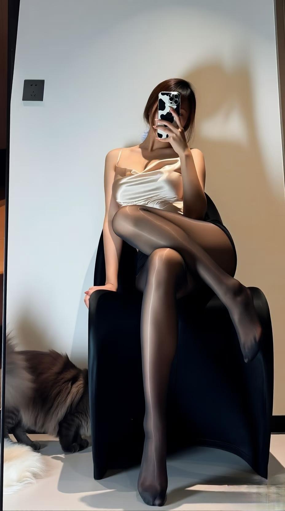 手机举到脸前时,丝滑的香槟色吊带蹭了下锁骨。黑丝袜在腿上泛着细闪的光,和旁边那团