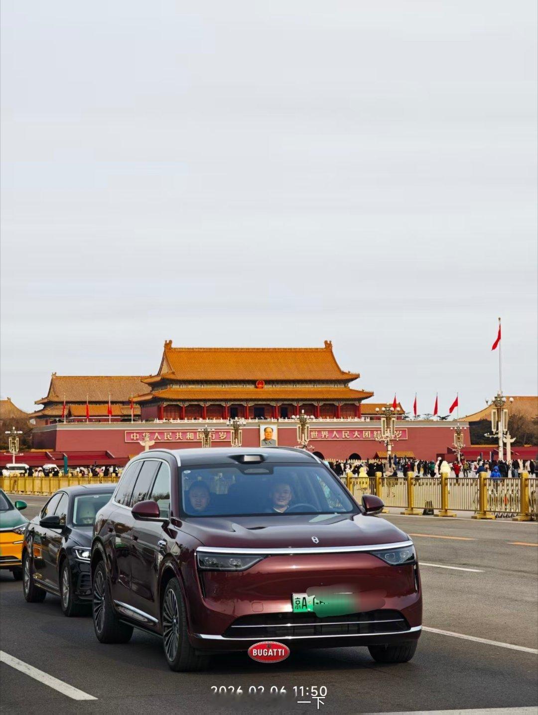 被拍到的问界M8车主笑盈盈地看着拍照的人，心想自己的M8难得能和天安门合个影