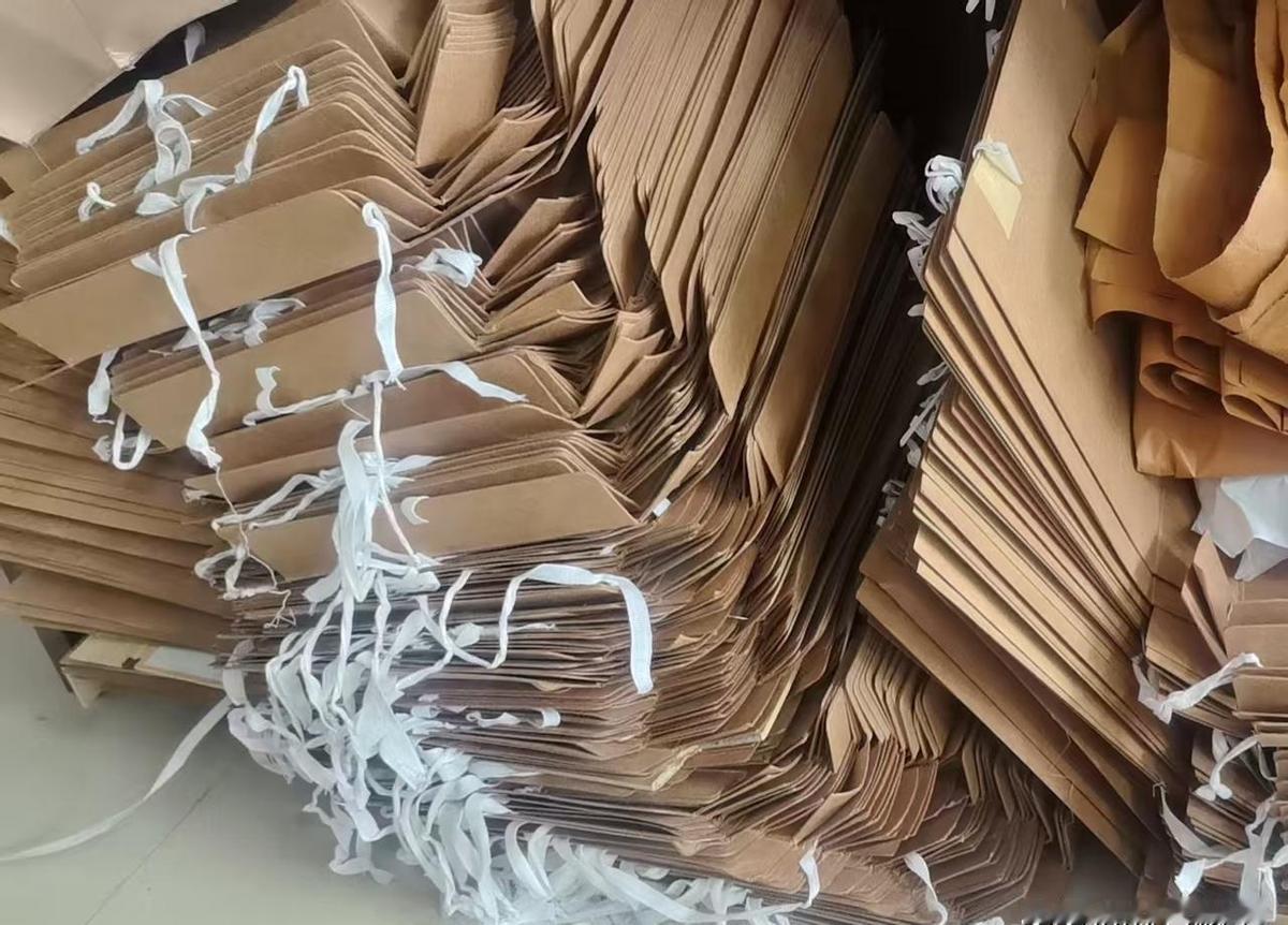 三捆纸壳多换20块现金，秘密藏在第六家废品站的秤杆上。电动车驮着130斤纸壳连